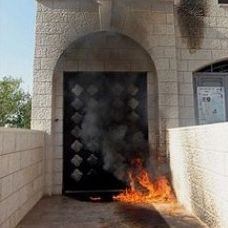 Flames are seen at the entrance of an Anglican church hit by a firebomb in Nablus. Photo: AP